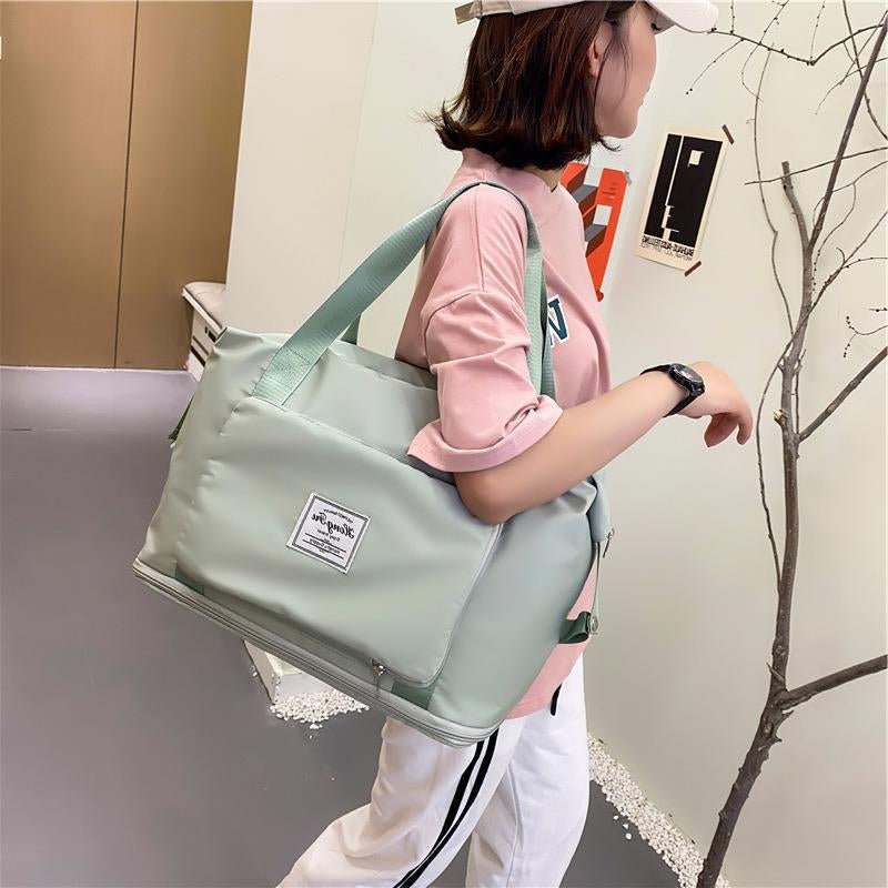 Travel Gym Bag in a stylish mint green color being carried by a woman, showcasing its foldable and waterproof design.